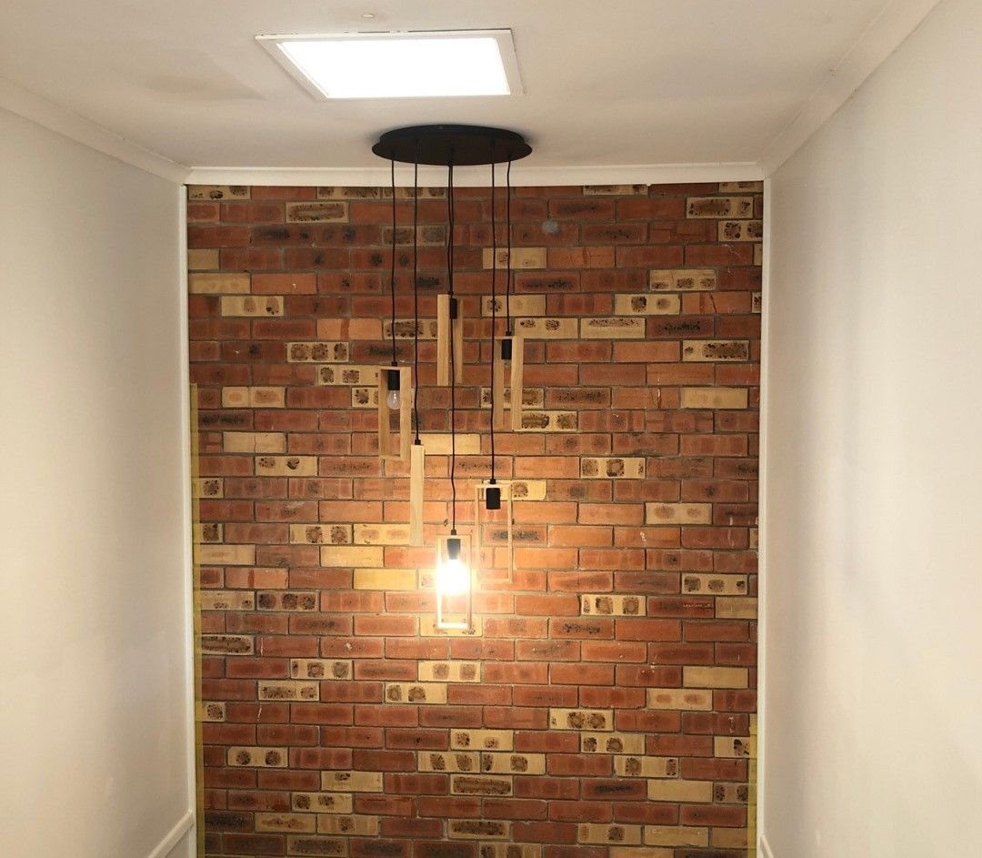 A Room With A Brick Wall And A Light Hanging From The Ceiling — Joyner Electrical Pty Ltd In Carrara, QLD 