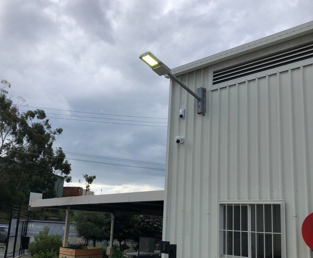 A White Building With A Street Light On The Side Of It — Joyner Electrical Pty Ltd In Carrara, QLD 