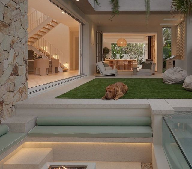 A Dog Is Laying On The Grass In Front Of A Staircase — Joyner Electrical Pty Ltd In Carrara, QLD