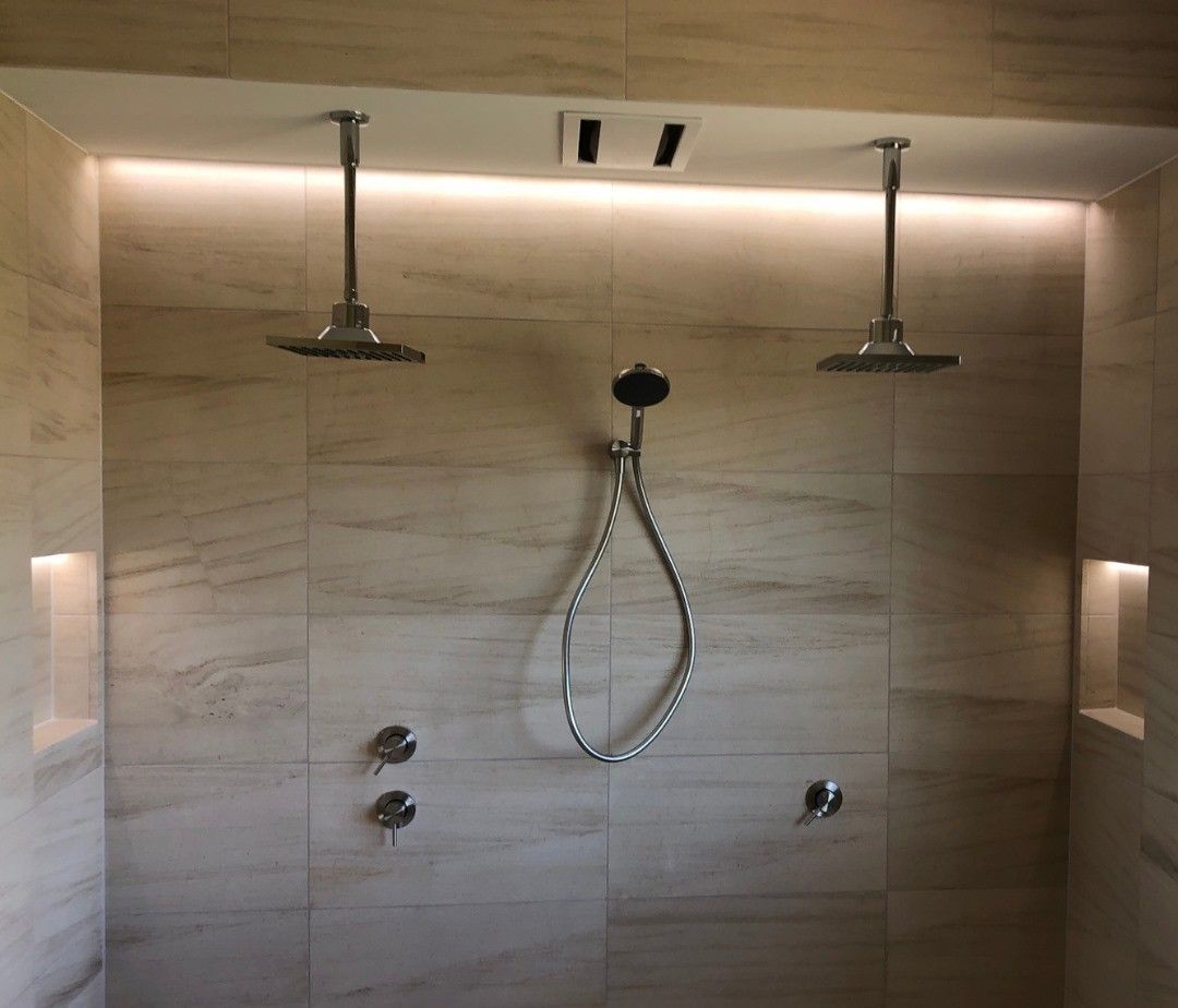 A Shower With Two Shower Heads Hanging From The Ceiling — Joyner Electrical Pty Ltd In Nerang, QLD 