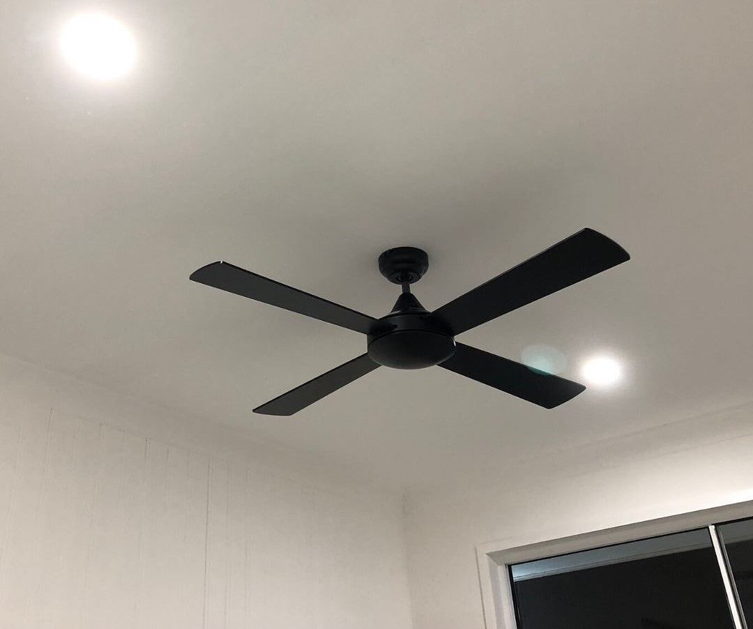 A Black Ceiling Fan Is Hanging From The Ceiling Of A Room — Joyner Electrical Pty Ltd In Carrara, QLD
