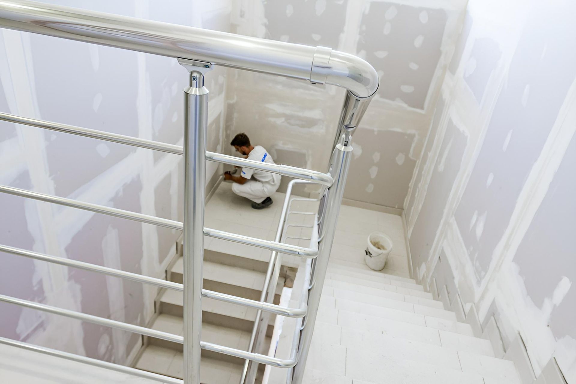 A Man is Sitting on the Floor Next to a Staircase — Tropical Coats Painting Whitsundays in Cannonvale, QLD