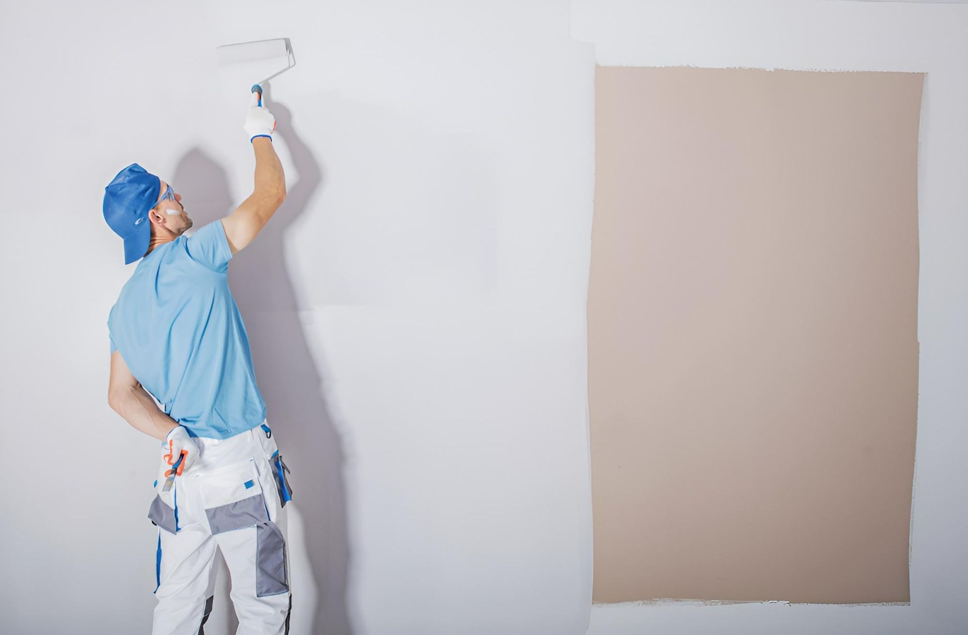 A Man is Plastering a Wall With a Trowel — Tropical Coats Painting Whitsundays in Cannonvale, QLD