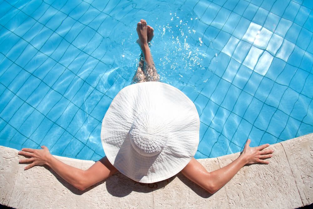 A Woman in a White Hat is Laying on the Edge of a Swimming Pool — Dunckers in Nambour, QLD