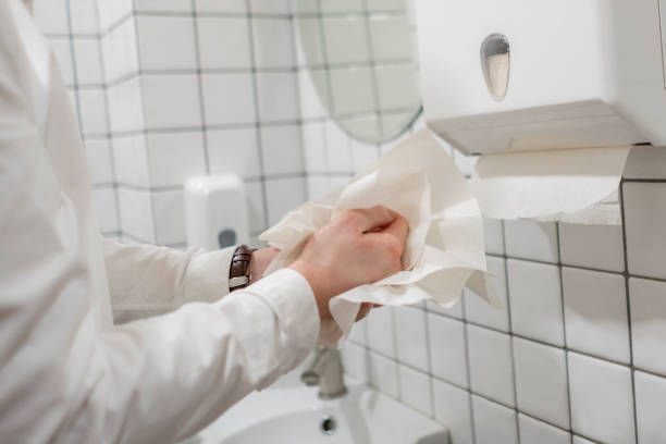 A Man is Using a Paper Towel Dispenser in a Bathroom — Dunckers in Nambour, QLD