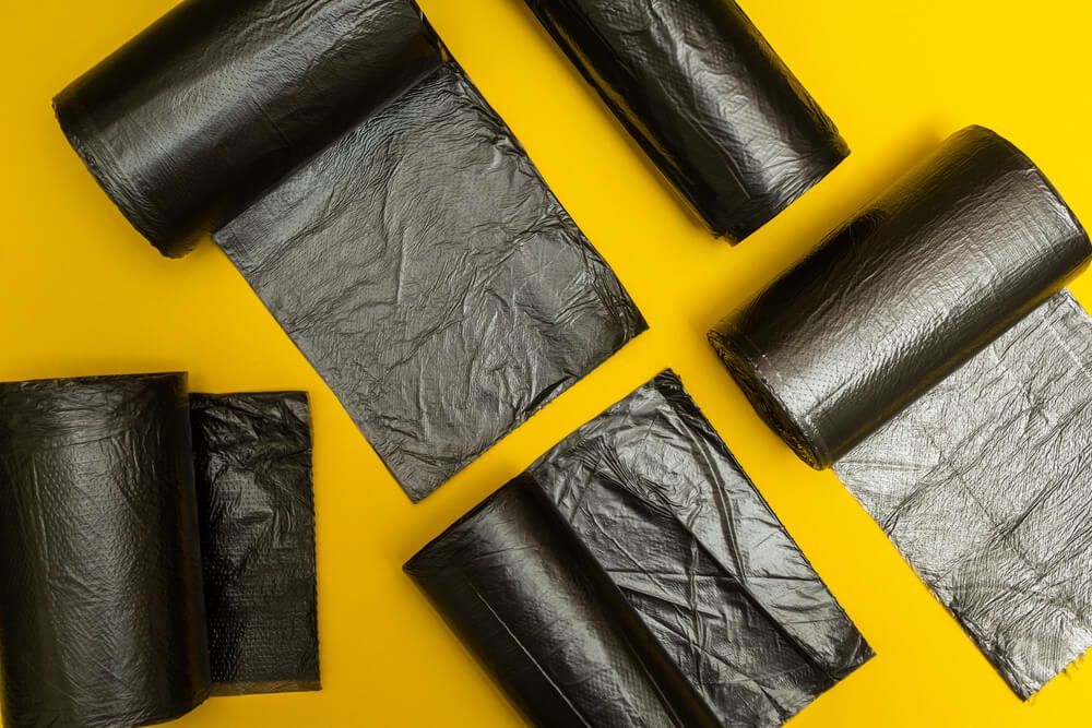 There are Many Different Rolls of Black Trash Bags on a Yellow Background — Dunckers in Nambour, QLD