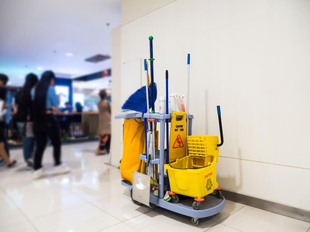 A Cleaning Cart With a Yellow Bucket and Mop in a Mall — Dunckers in Nambour, QLD