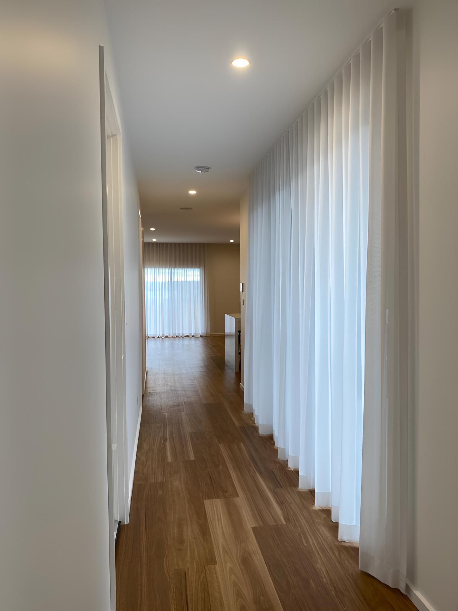 A Long Hallway With White Curtains — Elite Window Furnishings In Fyshwick, ACT