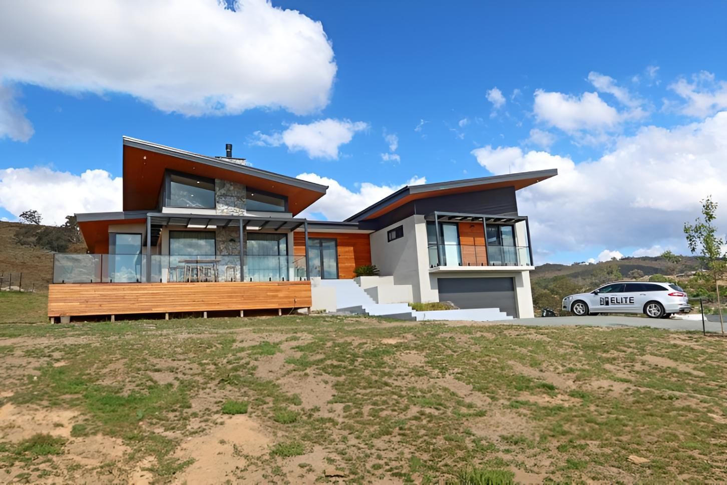 A Large House With a Car Parked in Front of It — Elite Window Furnishings In Fyshwick, ACT