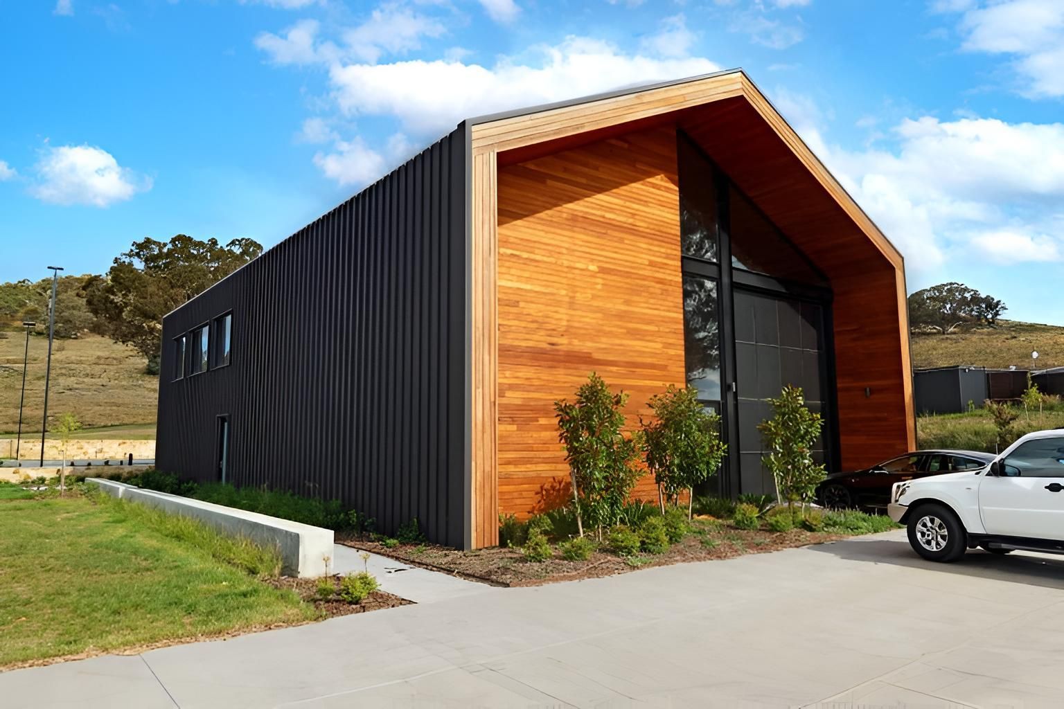 A White Truck is Parked in Front of a Large Wooden Building — Elite Window Furnishings In Fyshwick, ACT