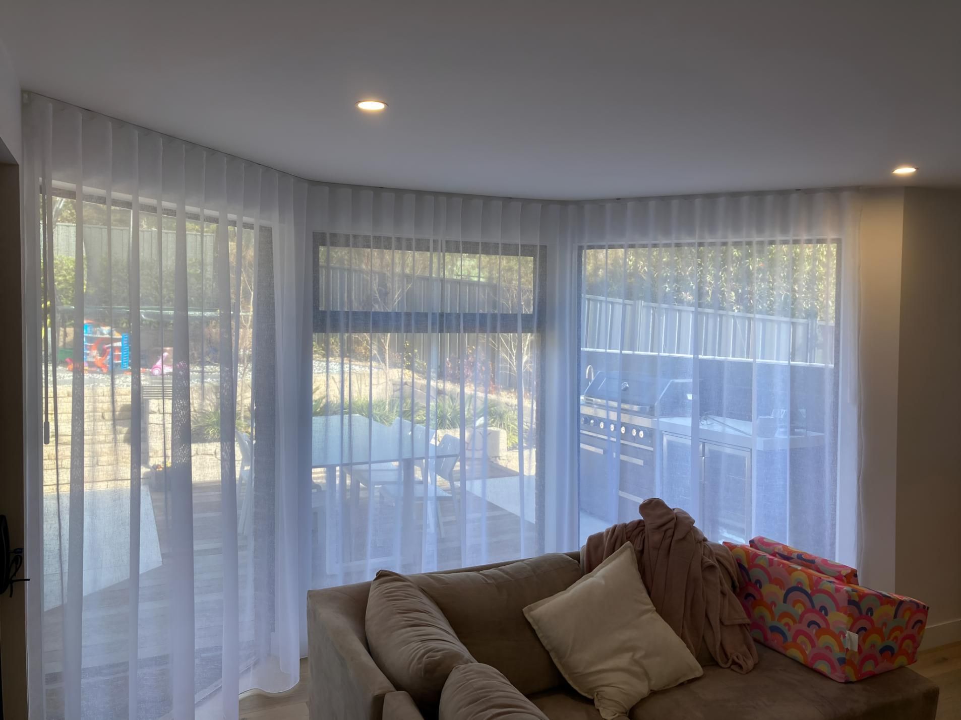 A Living Room With a Couch and Curtains on the Windows — Elite Window Furnishings In Tuggeranong, ACT
