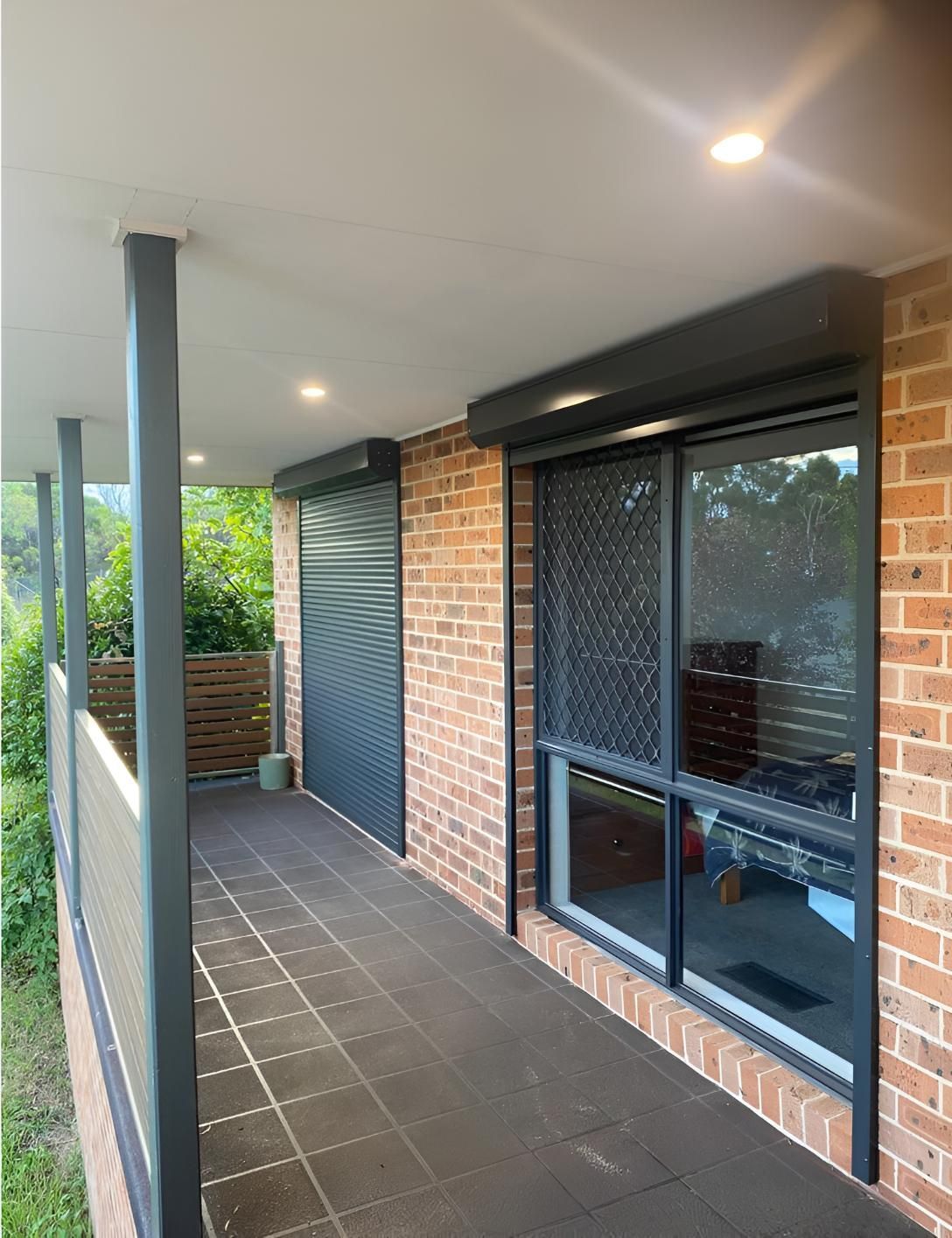 A brick building with a balcony and sliding glass doors — Elite Window Furnishings In Fyshwick, ACT