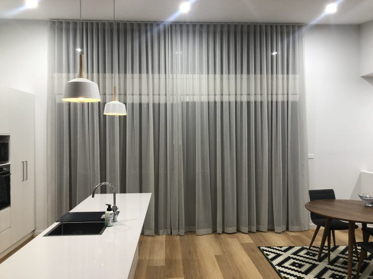 A kitchen with a table and chairs and curtains on the window — Elite Window Furnishings In Fyshwick, ACT