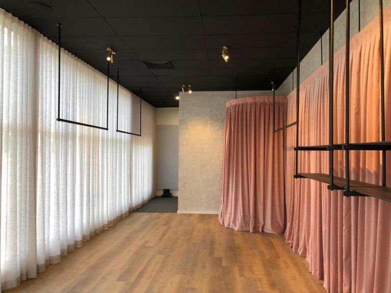 An Empty Room With Pink Curtains Hanging From the Ceiling — Elite Window Furnishings In Fyshwick, ACT