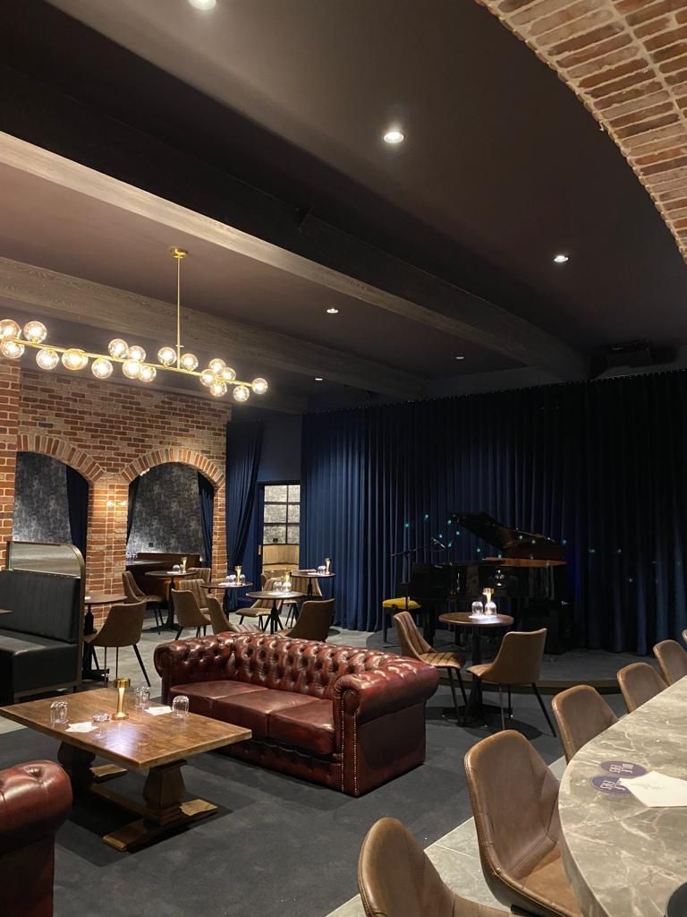 A Large Room With a Couch, Chairs, Tables and a Piano — Elite Window Furnishings In Fyshwick, ACT