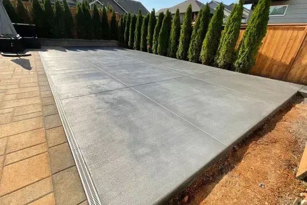 A green house with a concrete patio in front of it.