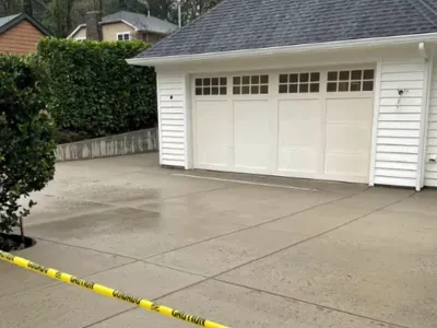 A white garage with a concrete driveway and a yellow caution tape in Salem, OR.
