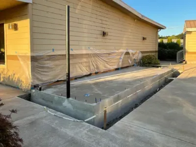 A concrete foundation is being built in front of a house in Salem, OR.