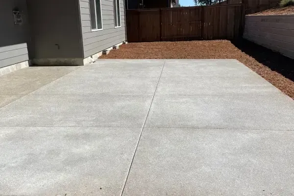 A white garage with a concrete driveway and a yellow caution tape.