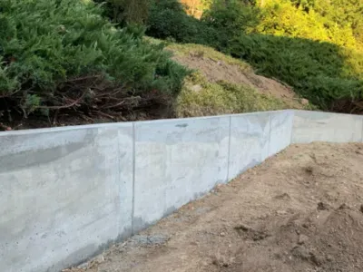A concrete retaining wall is being built in the middle of a dirt field in Salem, OR