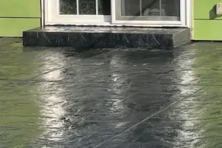Stamped concrete patio in front of a green house in Salem, OR