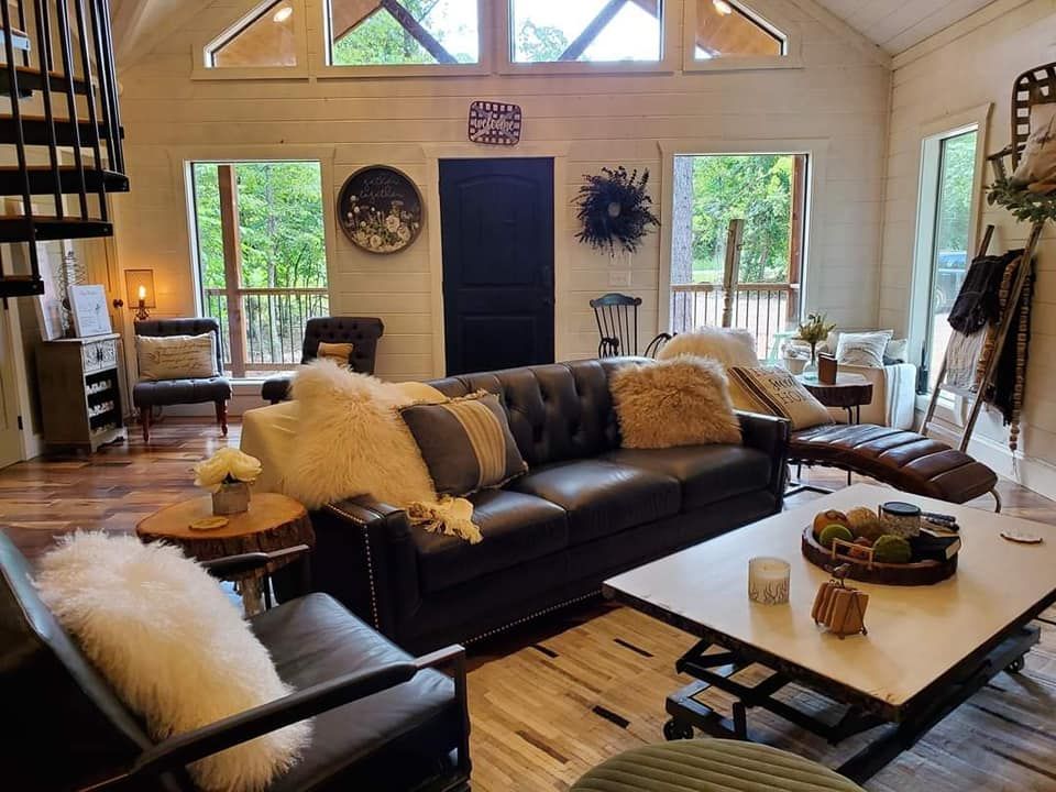 A living room with a couch , chairs , and a coffee table.