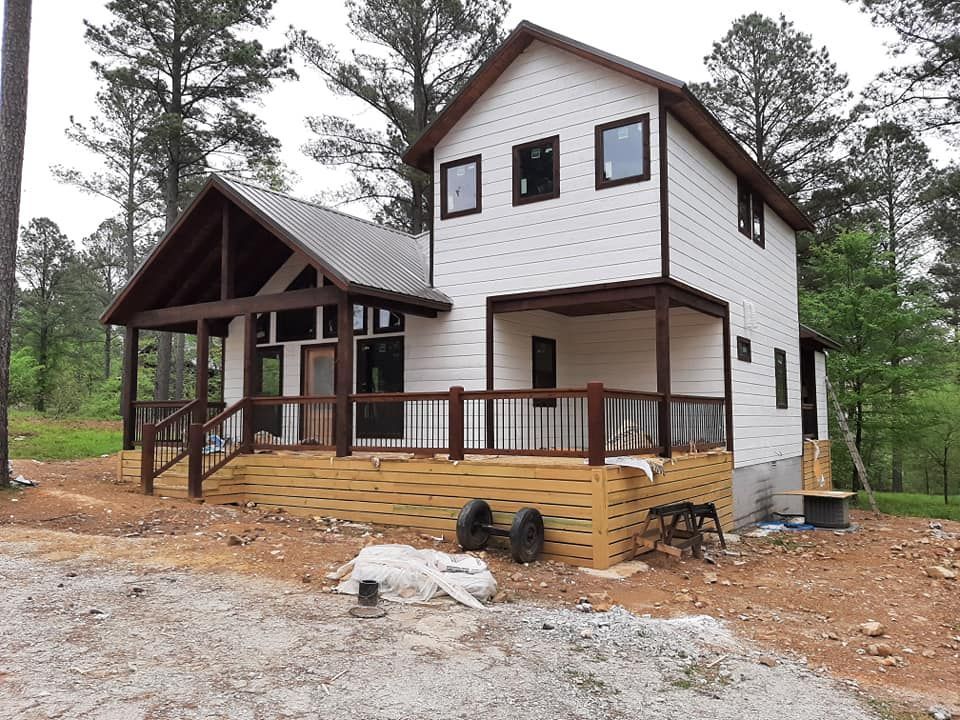 A white house with a wooden deck and stairs