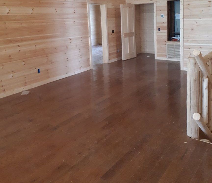 An empty room with hardwood floors and wooden walls