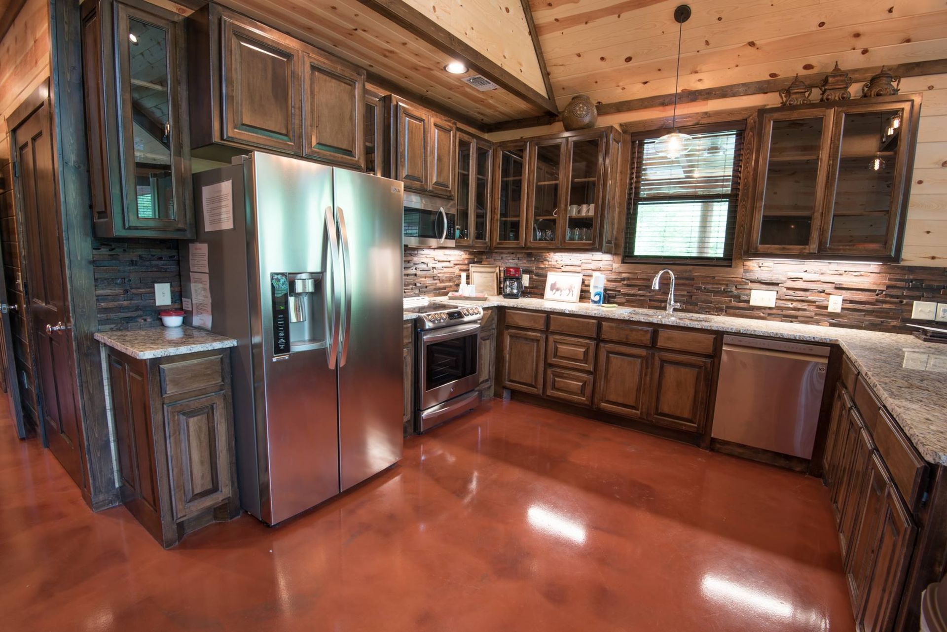 A large kitchen with stainless steel appliances and wooden cabinets.