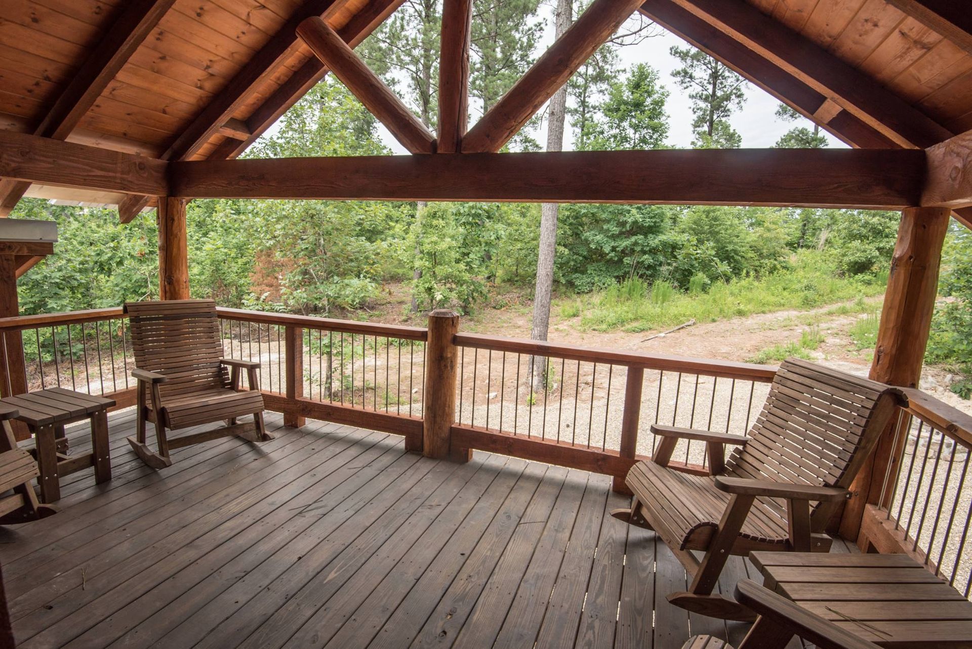 A wooden deck with rocking chairs and a table