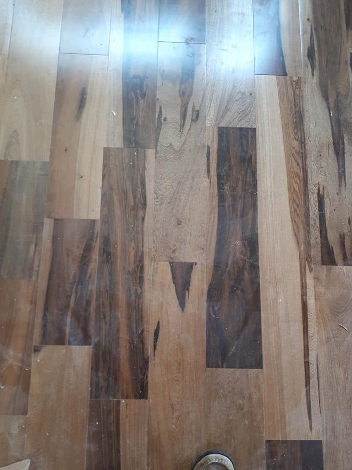 A close up of a wooden floor with a shoe on it.