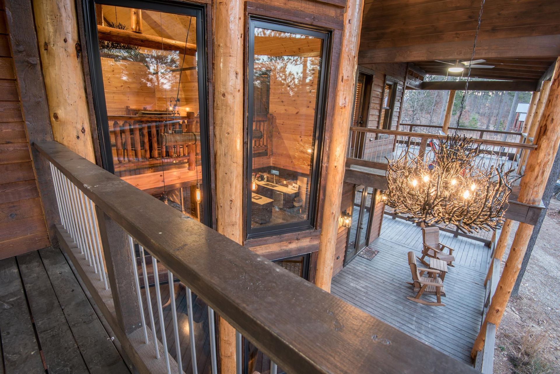 An aerial view of a log cabin with a balcony and a chandelier.