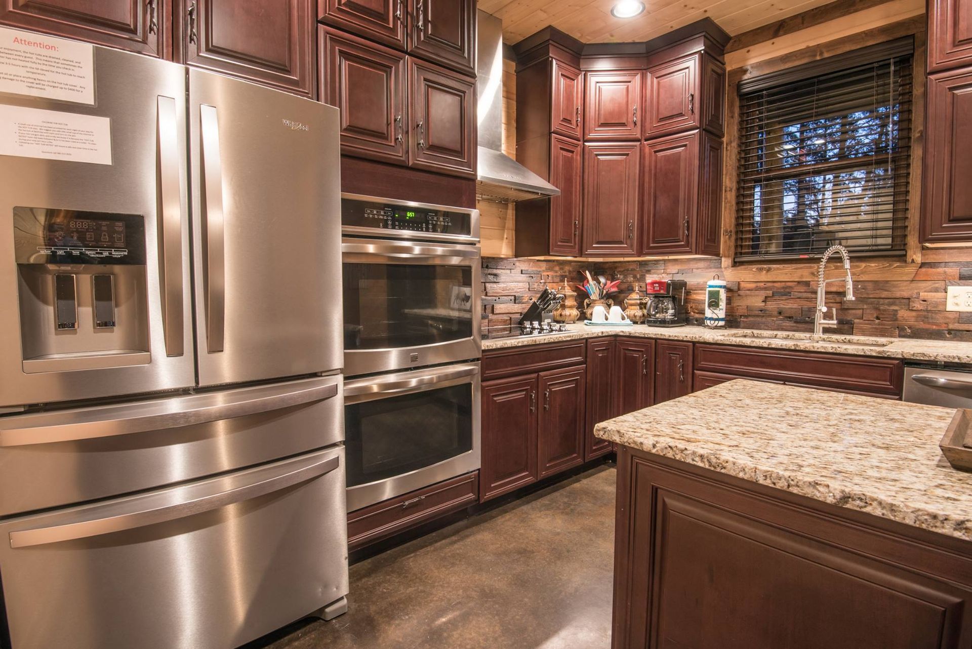 A kitchen with stainless steel appliances and granite counter tops.