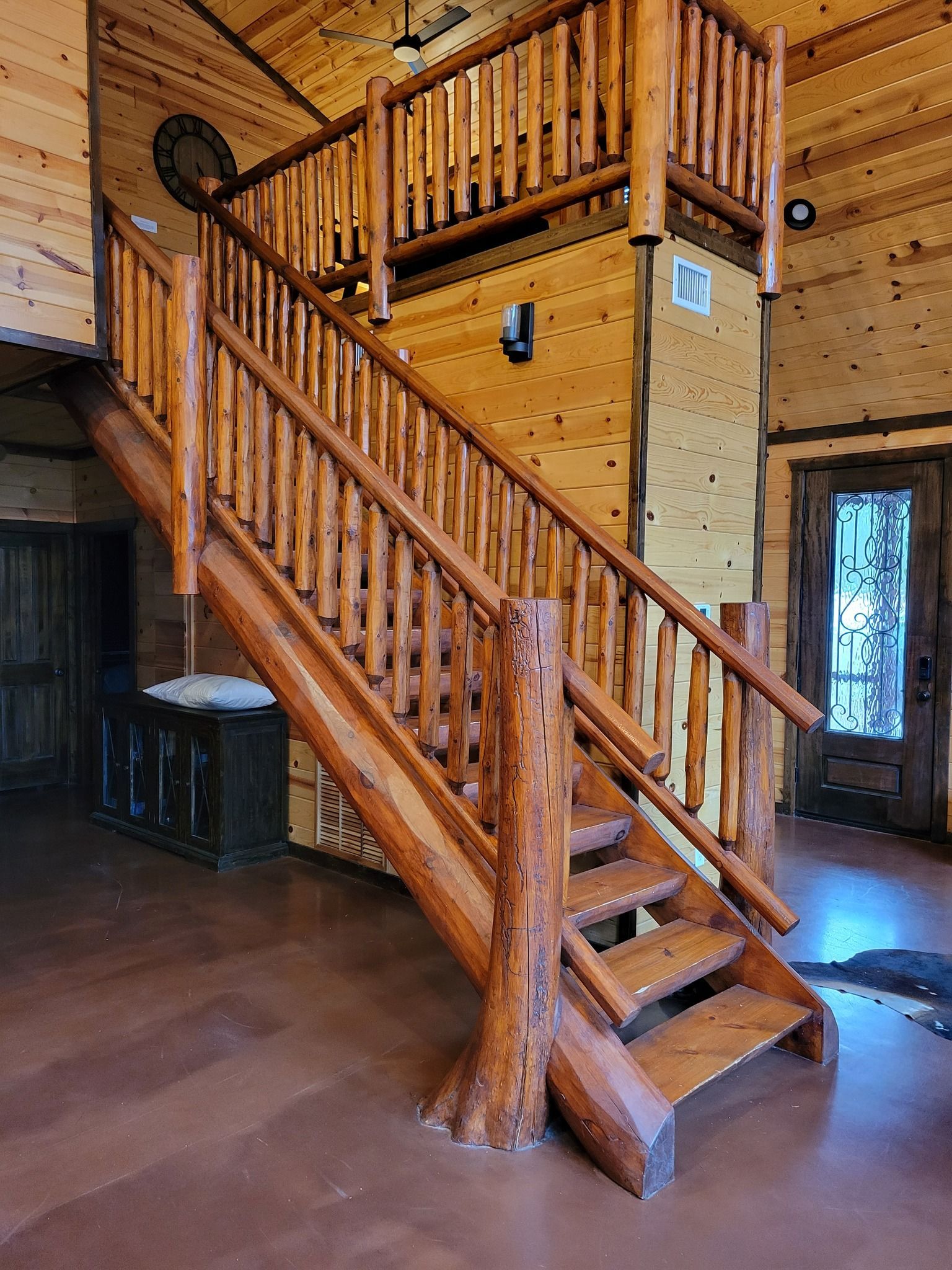 A wooden staircase leading up to a second floor in a log cabin.