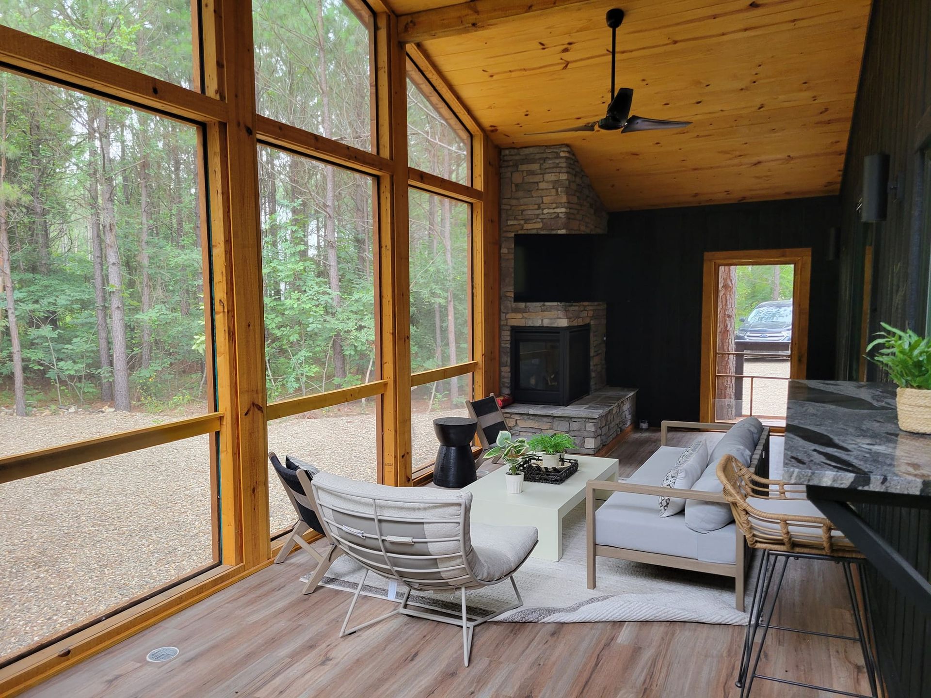 A living room with a lot of windows and a fireplace.