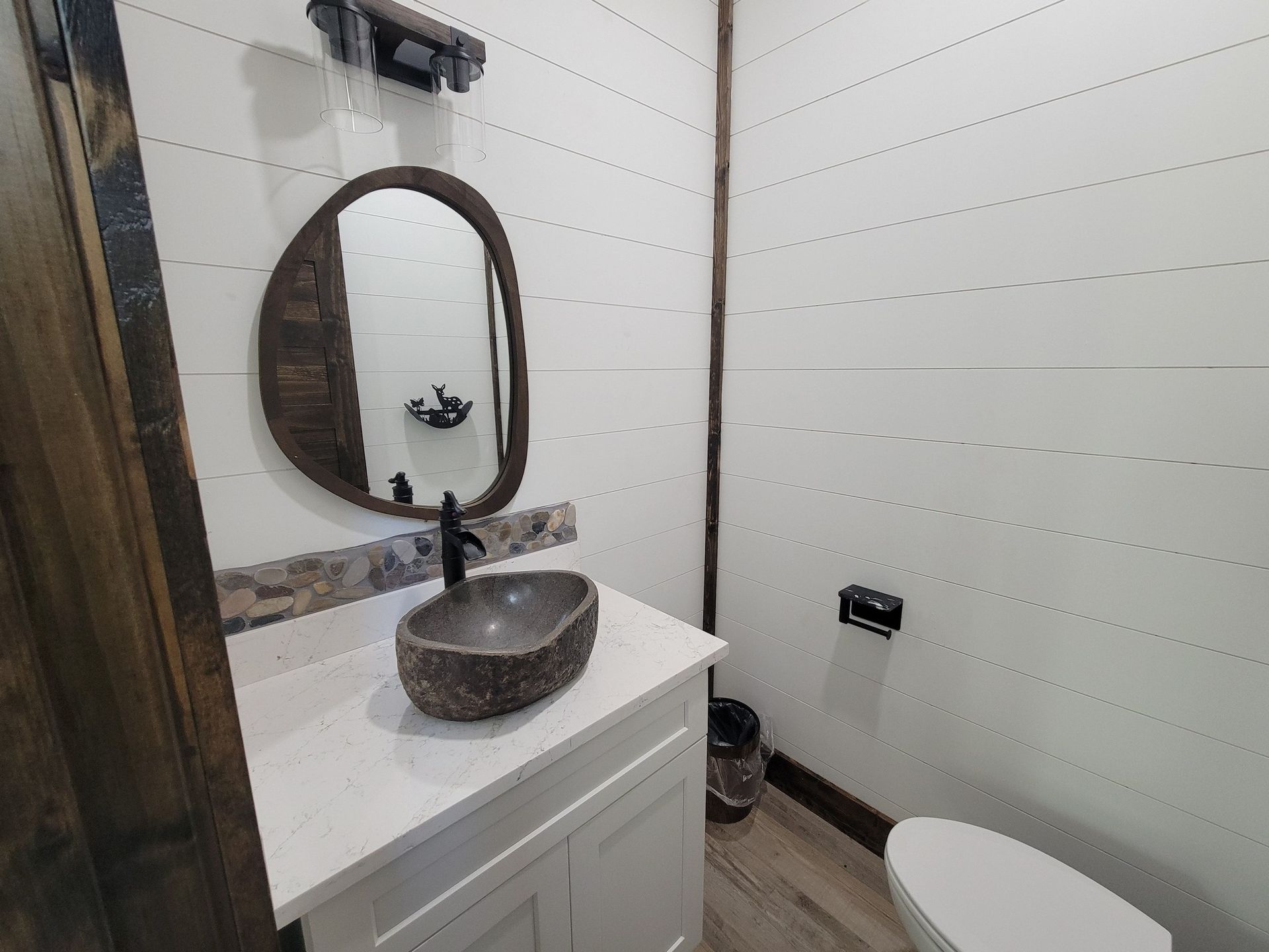 A bathroom with a sink , toilet and mirror.