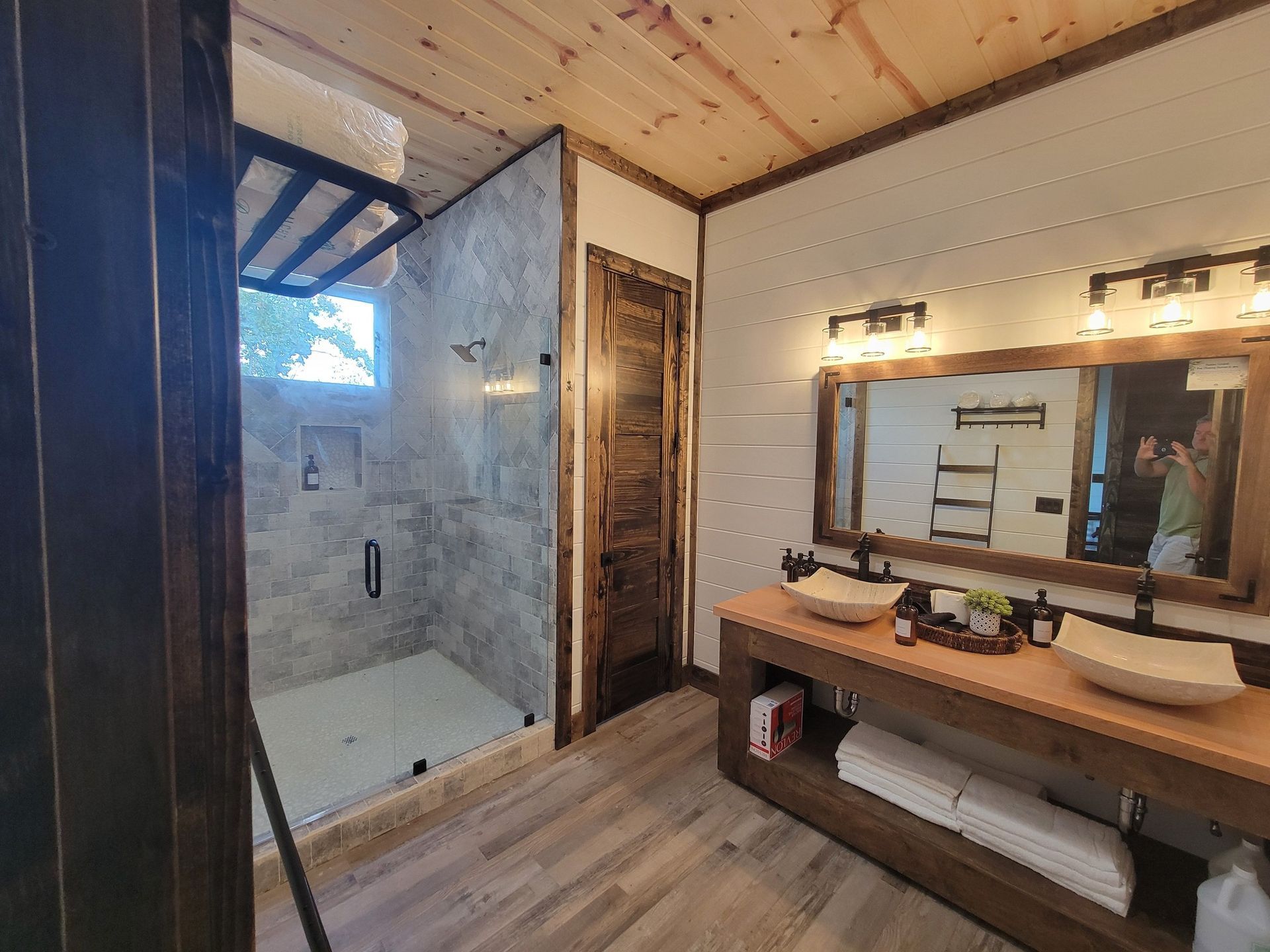 A bathroom with two sinks and a walk in shower.