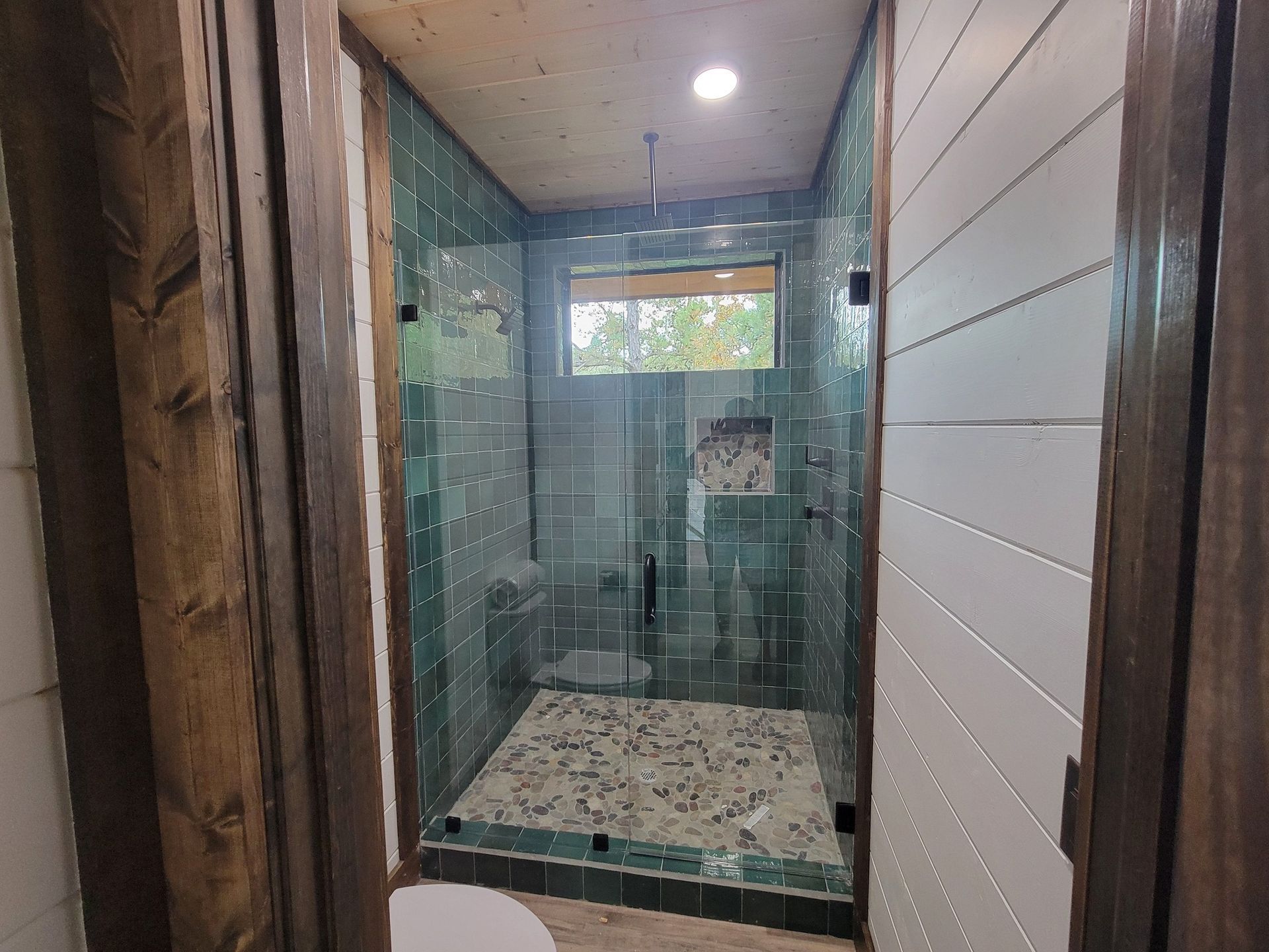 A bathroom with a walk in shower and a toilet.