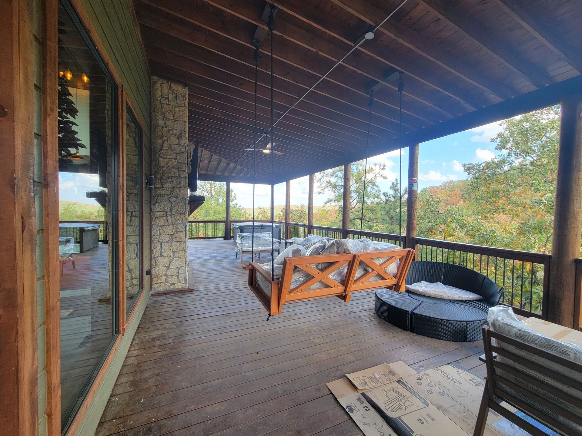 There is a porch with a swing and a couch on it.