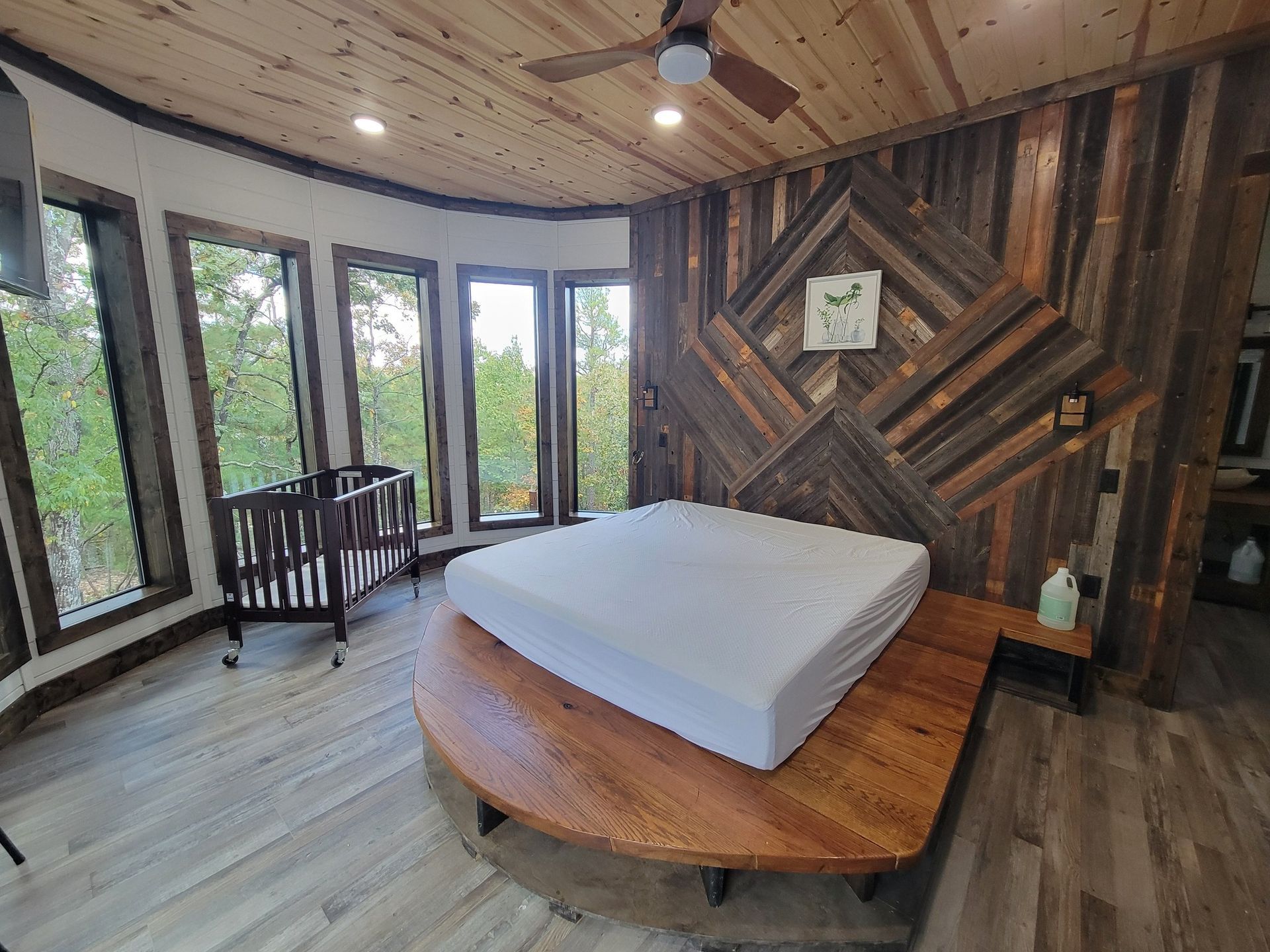 A bedroom with a large bed and a crib.