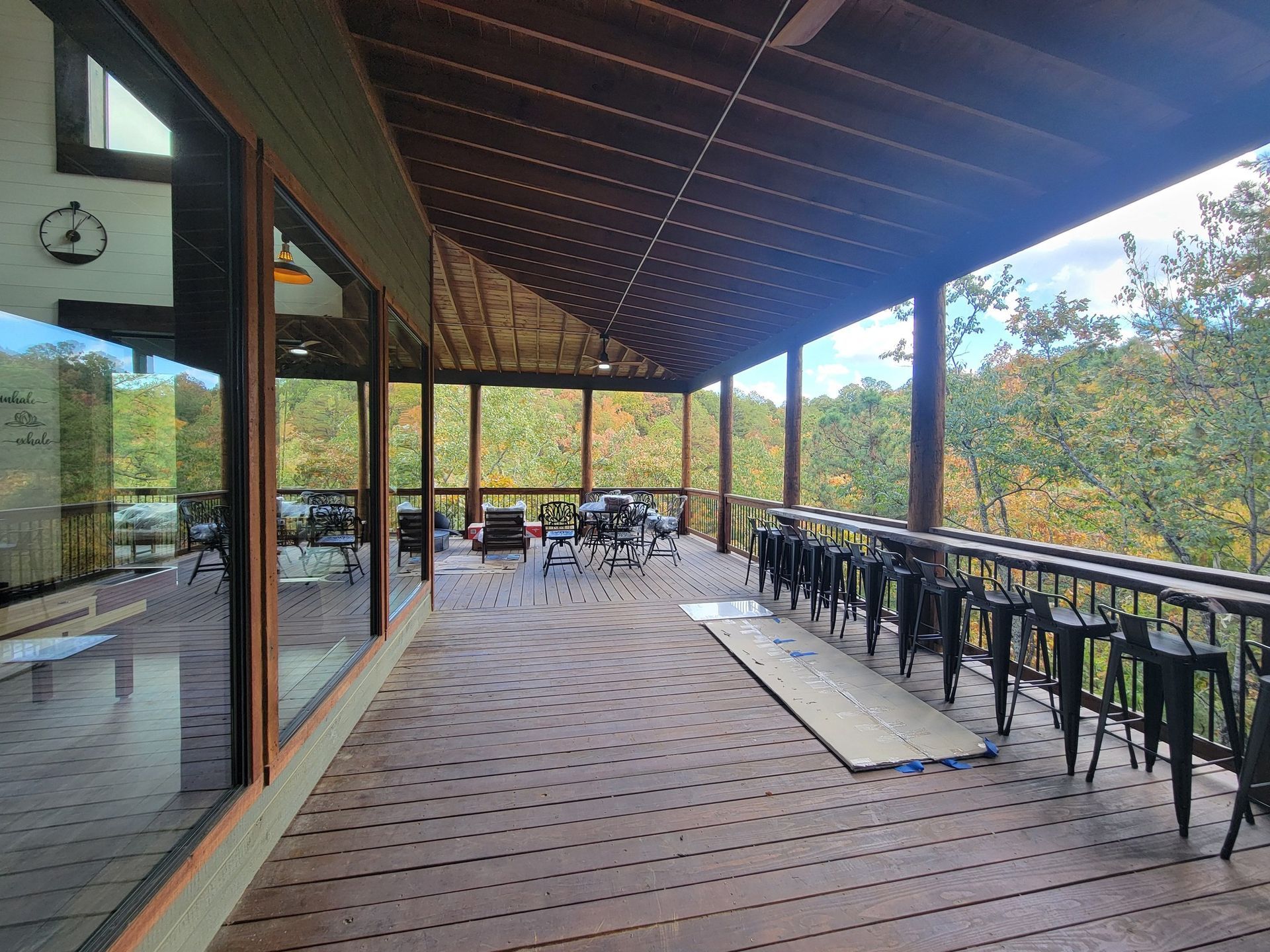 A large deck with a lot of chairs and tables on it.