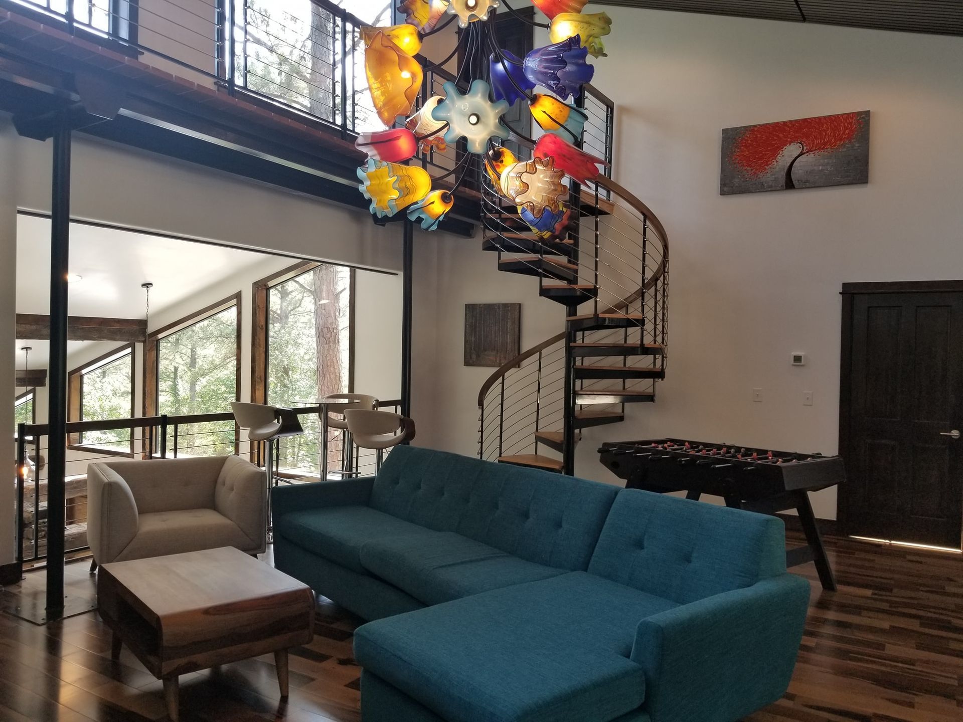 A living room with a blue couch and a spiral staircase