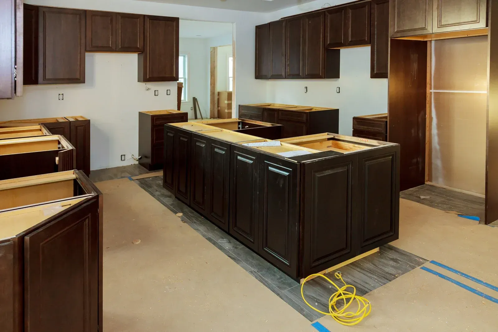 A kitchen under construction with a large island in the middle.