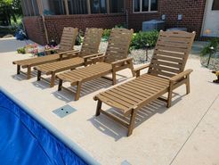 A row of wooden lounge chairs sitting next to a swimming pool.