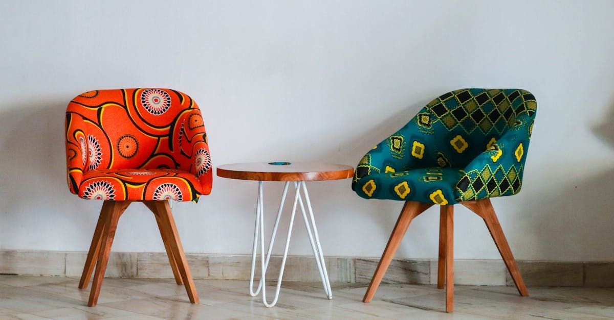 Two colorful chairs are sitting next to a small table.