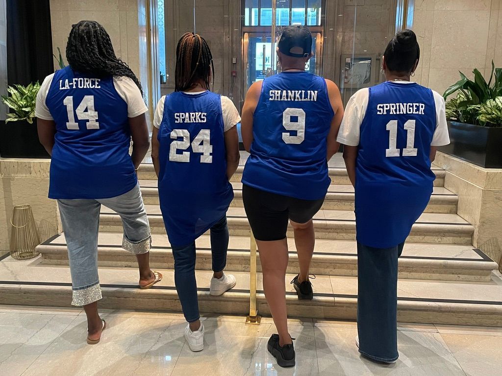 Basketball referee holding a basketball; black and white with orange ball.