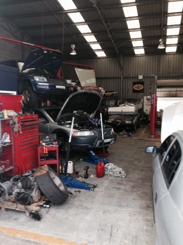 A Car is Being Worked on in a Garage With the Hood Up — Port Macquarie Automotive Specialists in Port Macquarie, NSW