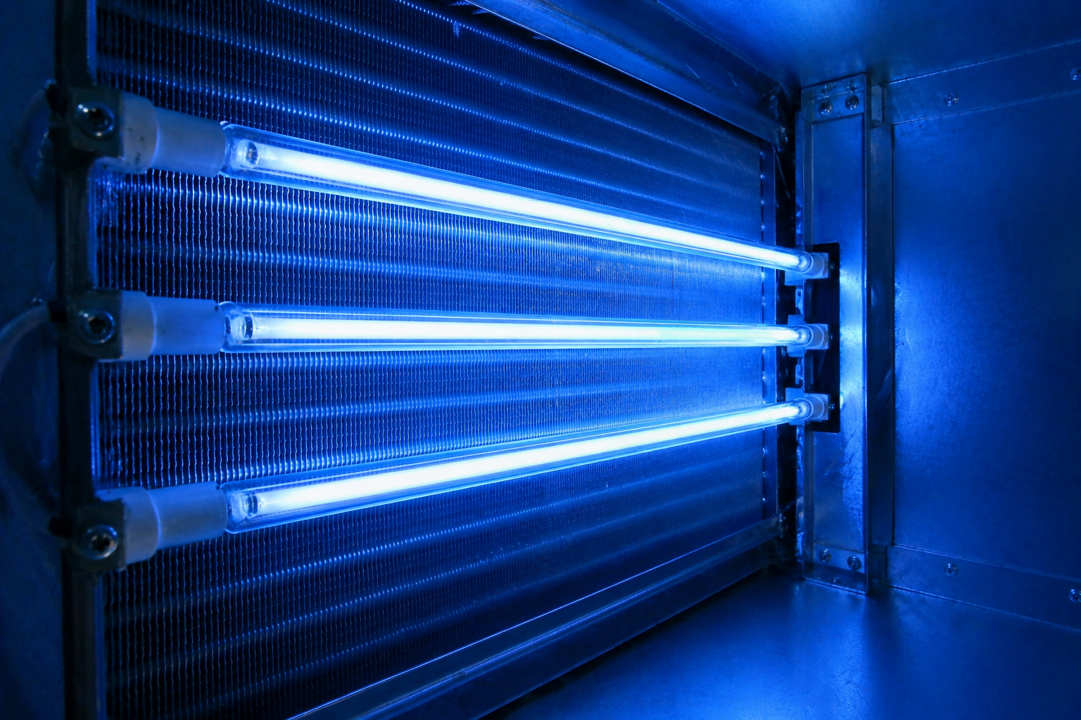 Blue-lit industrial UV/fluorescent tubes mounted in a metal frame inside a dark room