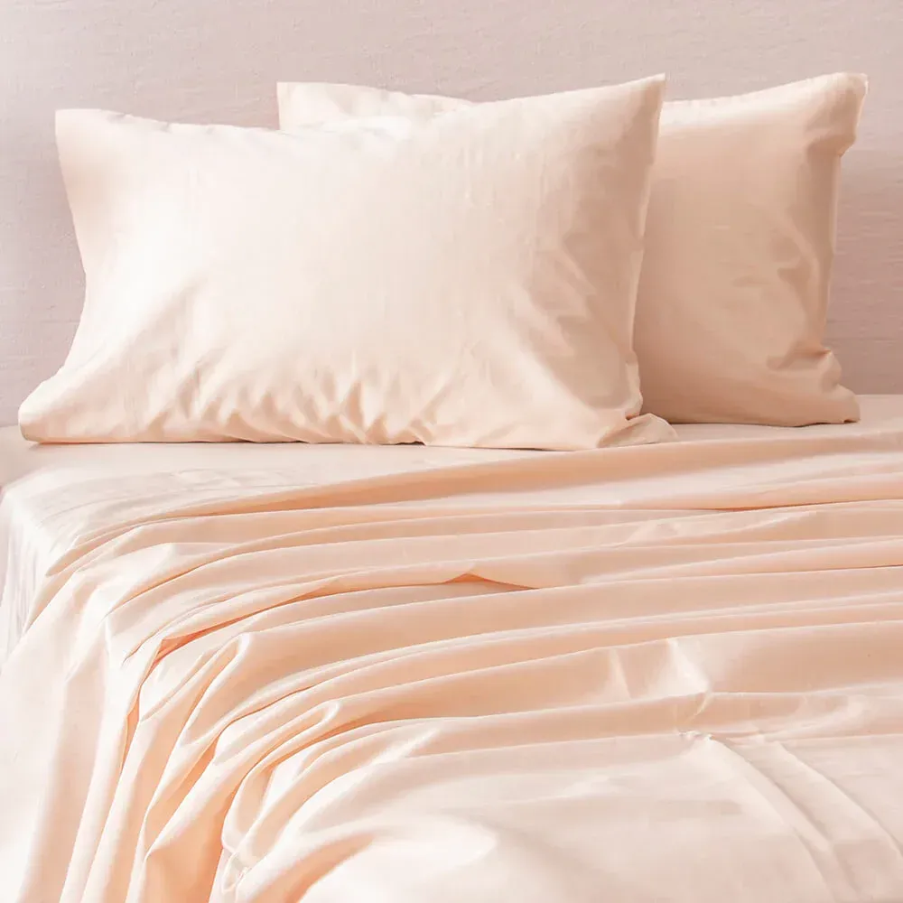 Una cama con cabecero y estructura de color marrón en una habitación con iluminación cálida.