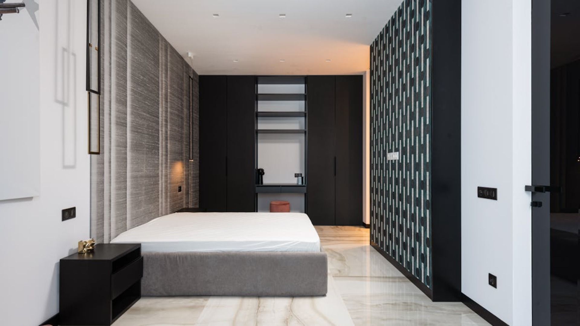 Un pequeño espacio de estar con pisos de apariencia madera, un sofá azul y juguetes de peluche coloridos.